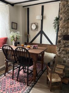 una sala da pranzo con tavolo e sedie in legno di Charming 2BR Cottage Retreat in the Centre of Bicester a Bicester