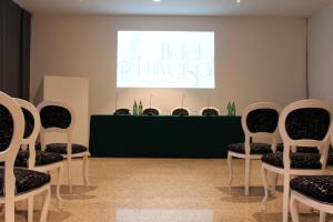 a group of chairs in a room with a presentation at Hotel Universal in Livorno