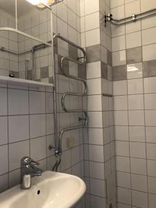 La salle de bains est pourvue d'un lavabo et d'un miroir. dans l'établissement Cozy Ostermalm Studio, à Stockholm