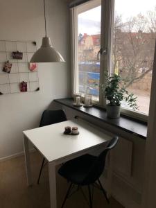 un tavolo bianco con sedie in una stanza con finestra di Lovely Ostermalm apartment a Stoccolma