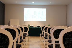 a row of chairs in a room with a screen at Hotel Universal in Livorno
