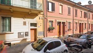 due auto parcheggiate in una strada accanto agli edifici di UR NEST Ceneri a Bologna