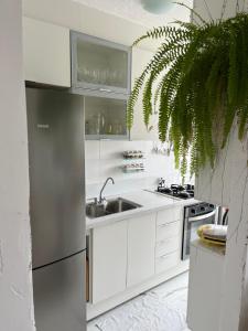 uma cozinha com armários brancos e um lavatório em Quarto ao Lado do autódromo de Interlagos em São Paulo