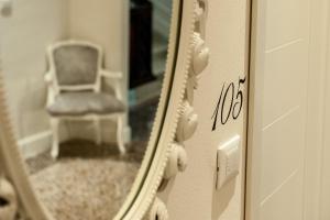 a mirror with a reflection of a chair in a room at Hotel Universal in Livorno