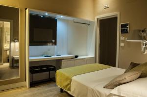 a bedroom with a bed and a desk with a mirror at Hotel Universal in Livorno
