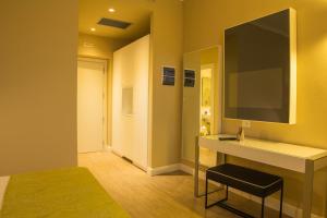 a room with a desk and a television on a wall at Hotel Universal in Livorno