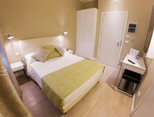 a small bedroom with a bed and a table at Hotel Universal in Livorno