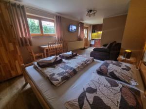 a bedroom with two beds and a living room at Wynajem u Andzi in Zakopane