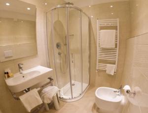 a bathroom with a shower and a sink and a toilet at Hotel Universal in Livorno