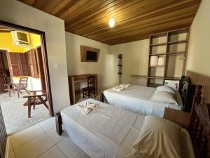 a hotel room with two beds and a balcony at Hotel Roma in São Sebastião