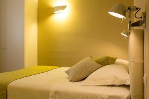 a bedroom with a bed with two pillows and a lamp at Hotel Universal in Livorno