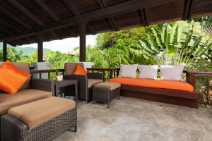 an outdoor patio with chairs and a bench at Ban's Diving Resort SHA Extra Plus in Ko Tao