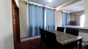 a dining room with blue curtains and a table with chairs at Hostal Sweet Dreams in Panajachel