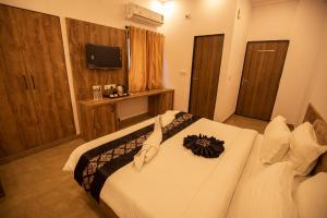 Schlafzimmer mit einem weißen Bett und einem TV in der Unterkunft Haridas Haveli by Charme Le Luxe in Udaipur