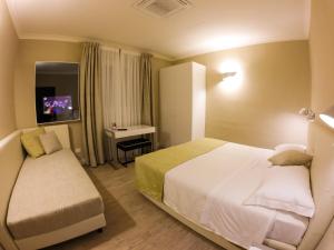 a hotel room with a bed and a desk at Hotel Universal in Livorno