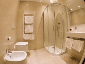 a bathroom with a shower and a toilet and a sink at Hotel Universal in Livorno