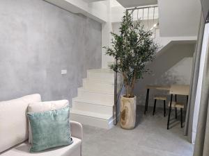 a living room with stairs and a plant in a vase at WEFLATING Fira in Hospitalet de Llobregat