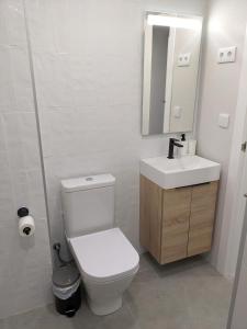ein Badezimmer mit einem WC, einem Waschbecken und einem Spiegel in der Unterkunft WEFLATING Fira in Hospitalet de Llobregat