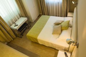 a bedroom with a bed and a table and a window at Hotel Universal in Livorno