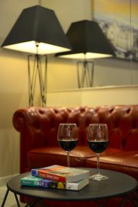 due bicchieri di vino su un tavolo accanto a un divano di Hotel Florence Milano a Milano