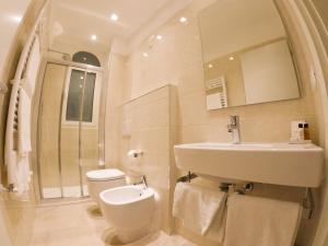 a white bathroom with a sink and a toilet at Hotel Universal in Livorno