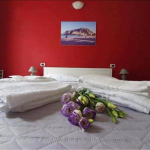 un letto bianco con un mazzo di fiori sopra di B&B Villareale 35 a Palermo