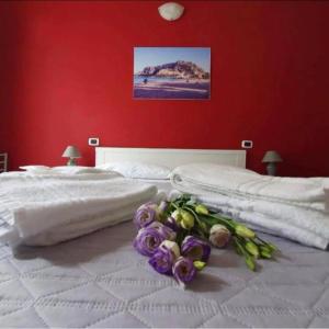 Una cama blanca con un ramo de flores. en B&B Villareale 35, en Palermo
