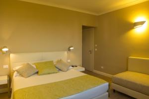 a bedroom with a bed and a chair at Hotel Universal in Livorno