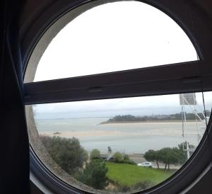 a round window with a view of the ocean at La Vigie perchée - Les Gîtes de la Côte d'Amour in Le Croisic