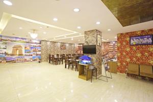 Habitación grande con un restaurante con mesa y sillas. en Hotel D'Capitol - Delhi Airport en Nueva Delhi