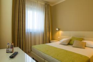a hotel room with a bed and a window at Hotel Universal in Livorno