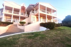 a large white building with a staircase in front of it at Marina View Villa in Gros Islet