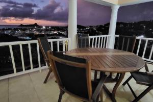 a wooden table and chairs on a balcony with a view at Marina View Villa in Gros Islet
