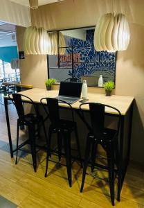 a dining room table with chairs and a laptop on it at Appart'City Confort Bordeaux Chartrons in Bordeaux