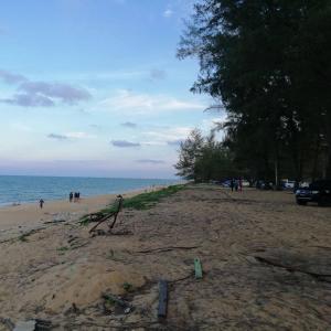 a beach with people walking on the sand and the ocean at Paka Seaview Inn in Paka