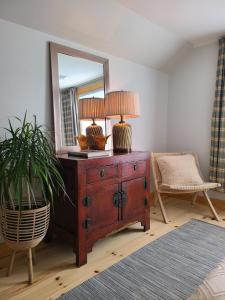 un comò in legno con uno specchio e una lampada sopra di La Petite Auberge Sur Queen a Rawdon