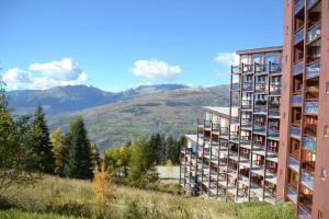 an apartment building with mountains in the background at Résidence Grand Arbois - Studio pour 2 Personnes 051 in Arc 1800