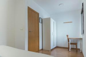 a bedroom with a door and a table and a chair at San Justo 3 in Huelva
