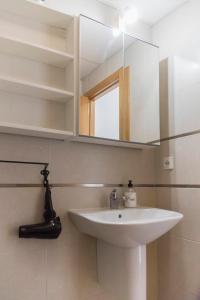 a bathroom with a white sink and a mirror at San Justo 3 in Huelva