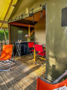 una terraza con sillas y una mesa en una tienda de campaña en Camping Le Lagon Bleu, en Notre-Dame-de-Monts