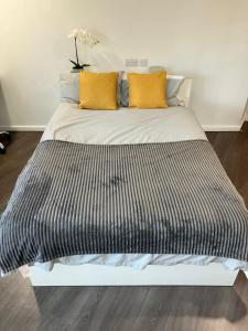 1 cama con sábanas blancas y negras y almohadas amarillas en Stunning Apartments at Laycock Studios, in Sheffield en Sheffield