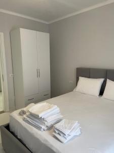 een witte slaapkamer met een bed en een witte kast bij Fishta hotels in Velipojë
