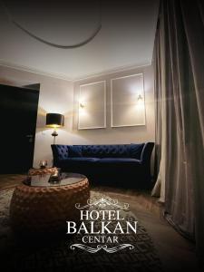 a living room with a blue couch and a table at Hotel Balkan Centar in Bijeljina