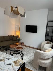 - un salon avec un canapé, des chaises et une télévision dans l'établissement Le Lyon, Brest superbe appartement de 120m2, à Brest