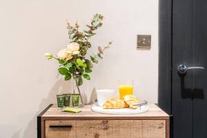 a table with a plate of pastries and a glass of orange juice at Wiverton Apt #4 - Central Location - Free Parking, Fast WiFi and Smart TV by Yoko Property in Nottingham