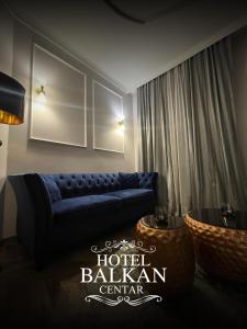 a living room with a blue couch in a room at Hotel Balkan Centar in Bijeljina