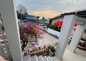 Blick auf einen Garten mit Blumen und ein Gebäude in der Unterkunft บ้านกานดา in Seka