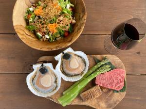 two wooden plates with a salad and a bowl of food at Wakka BBB in Teshikaga