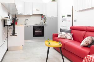 un soggiorno con divano rosso e tavolo giallo di la casa di gusto a La Spezia