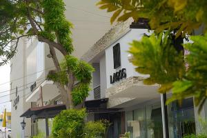 a white building with a tree in front of it at Lagos Apartaestudios x2 in Barranquilla